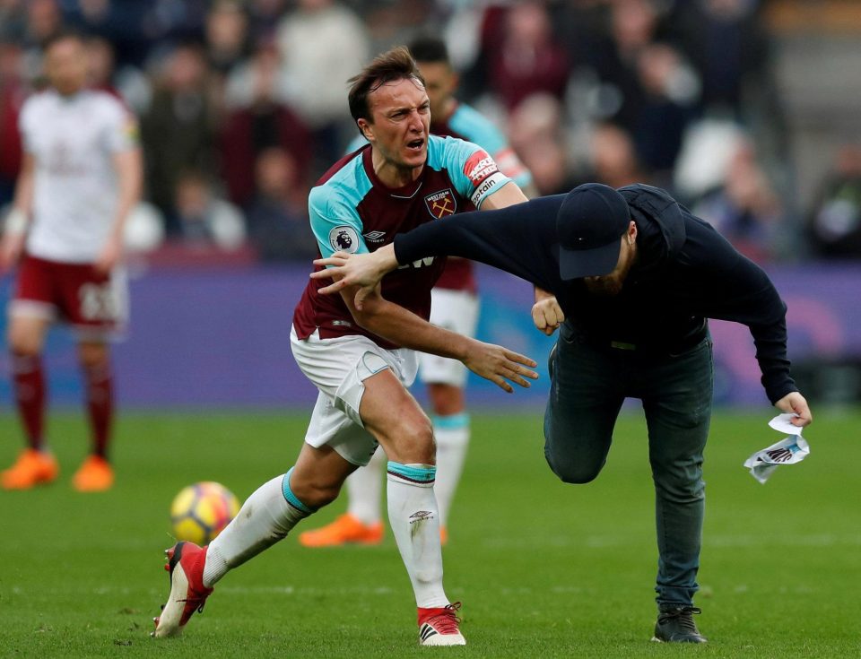  West Ham skipper Mark Noble clashes with a fan on the pitch at London Stadium