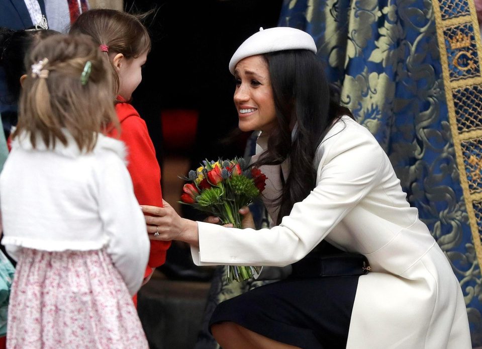  Meghan receives flowers as she leaves after attending the Commonwealth Service at Westminster Abbey