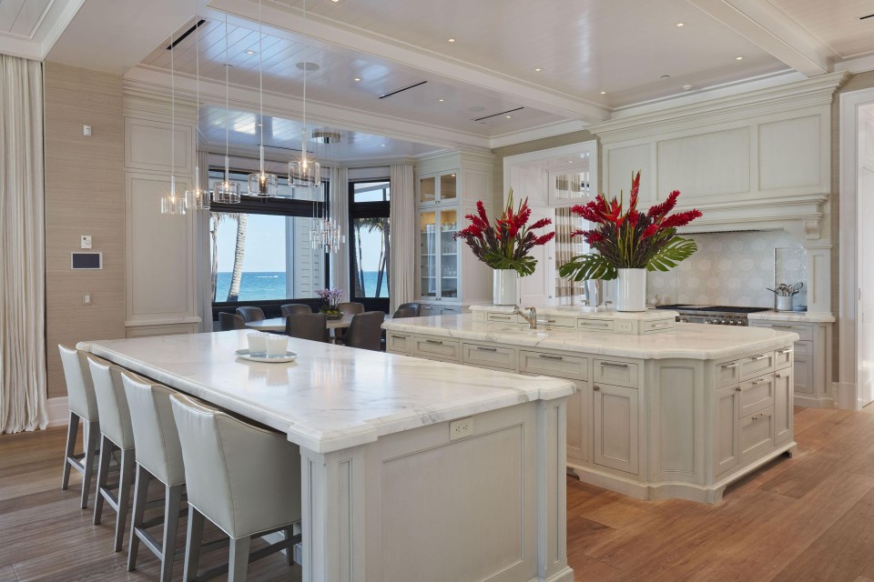 Beautiful kitchen includes a number of tables to eat at and stunning counters