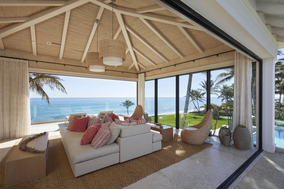 The mansion has a beach hut outside of it by the pool