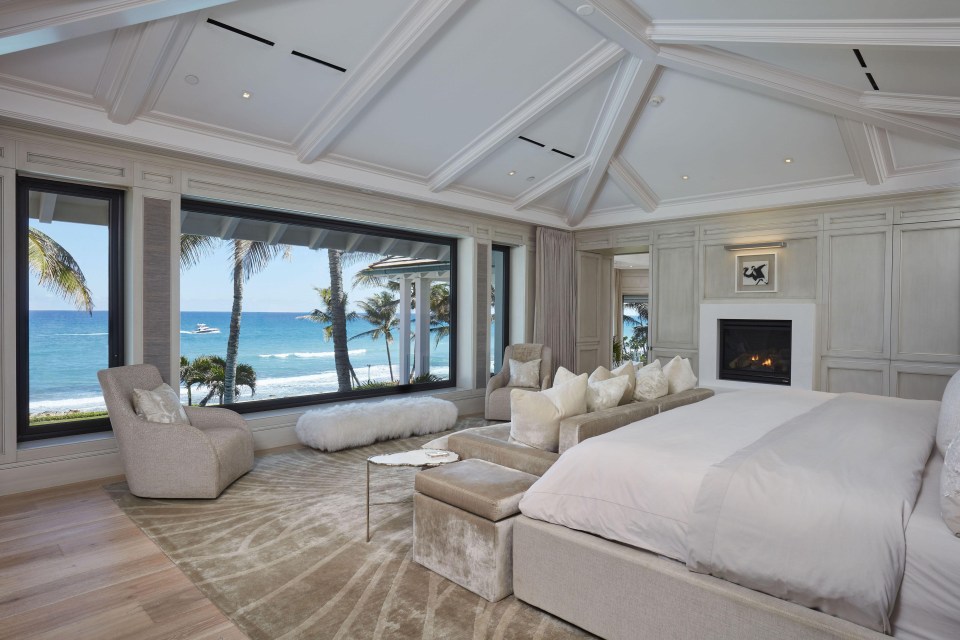 Stunning master bedroom has a view of the ocean and a built-in fireplace