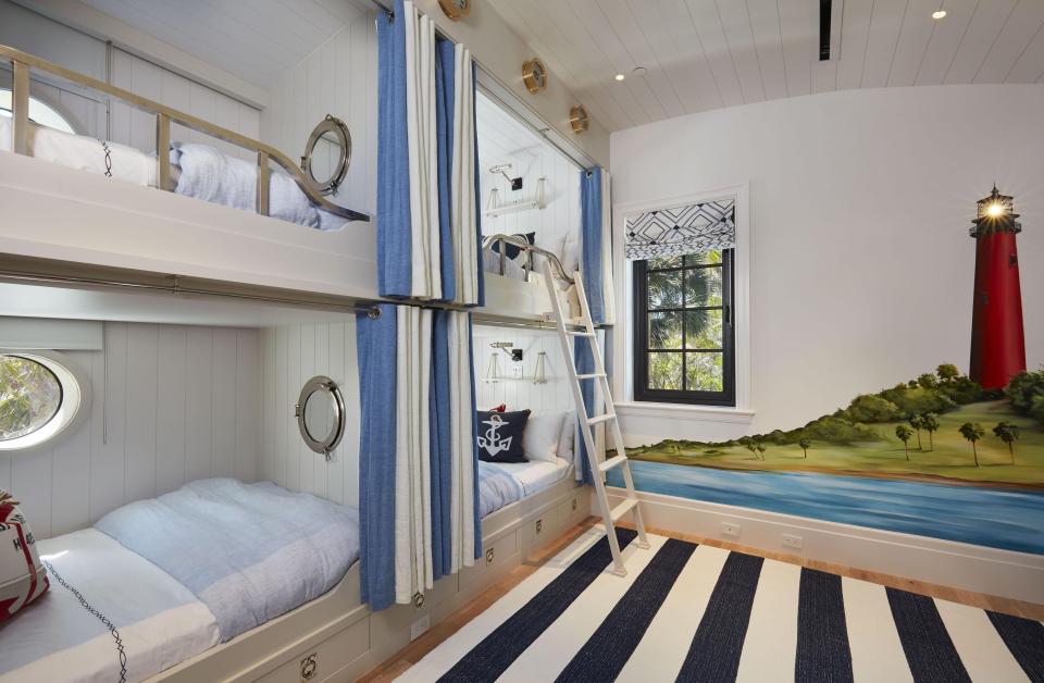  Two bunk beds are placed side-by-side in one bedroom with a lighthouse painting on the wall