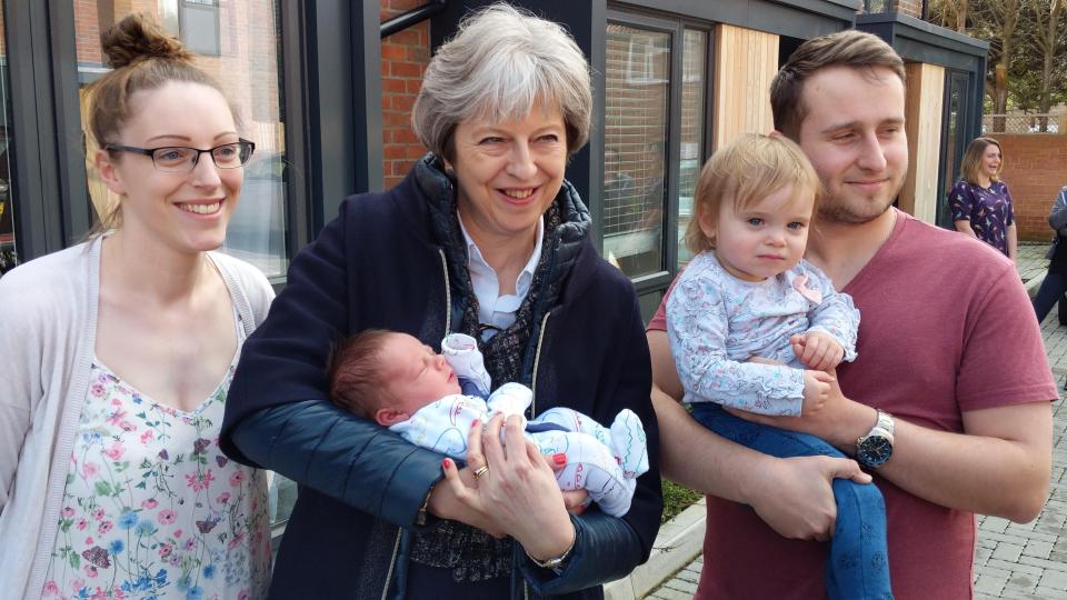  Theresa May, pictured holding six-day-old Ted Young in Wokingham today, has hit back against Russia