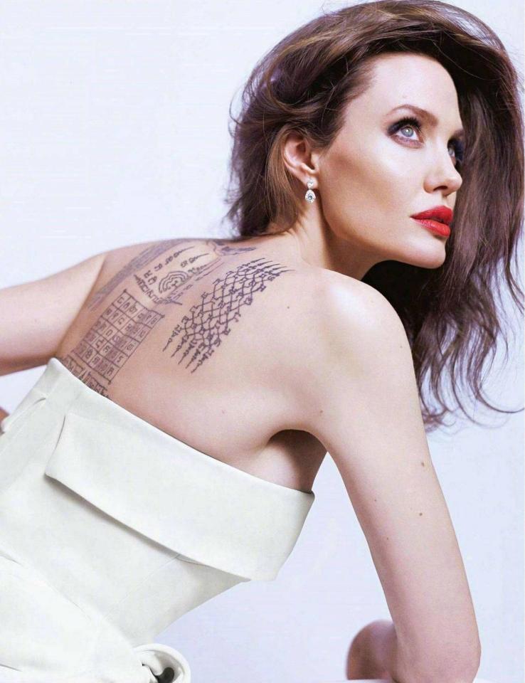  The 42-year-old actress displays her back tattoos that "symbolically bind her" with Brad