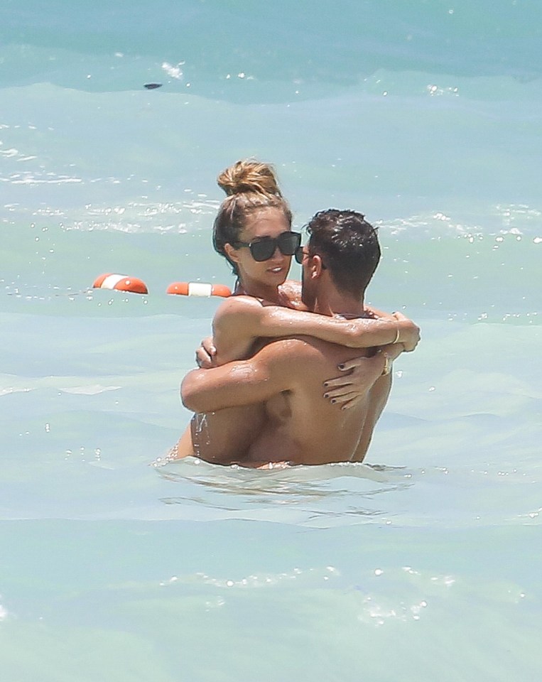 Megan looked smitten as Mike carried her through the shallow water