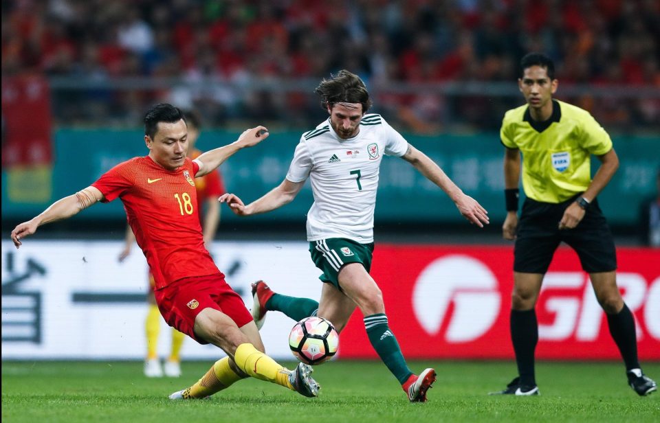  Gao Lin takes on Wales' Joe Allen during their China Cup match with his artwork covered up