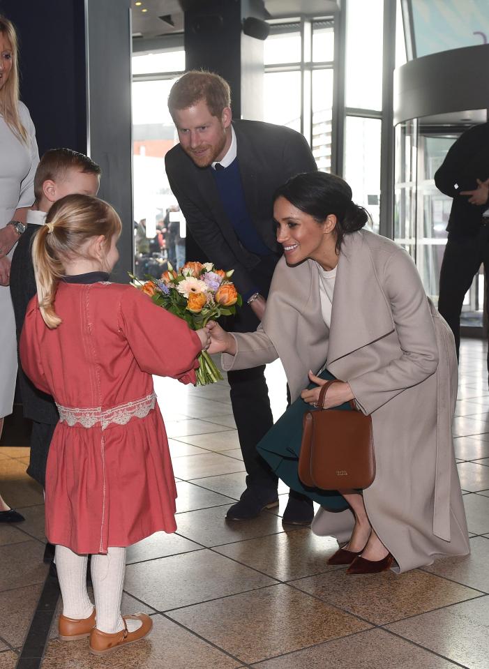  Prince Harry and Meghan Markle receive a posy of flowers during a visit to the iconic tourist attraction, Titanic in Belfast