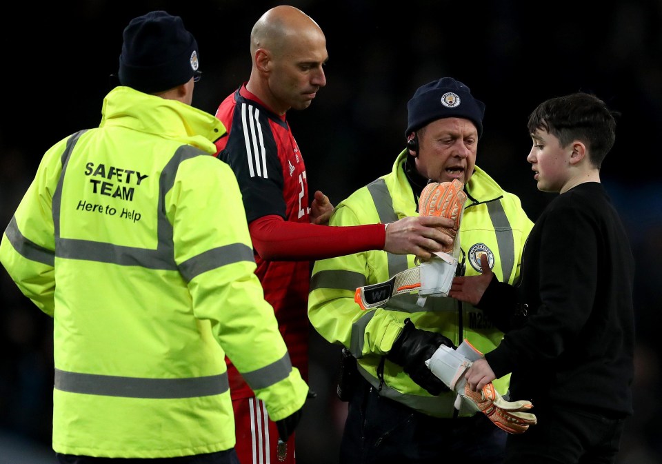 Argentina keeper Willy Caballero hands over his gloves to a young pitch invader at the Etihad in the game against Italy