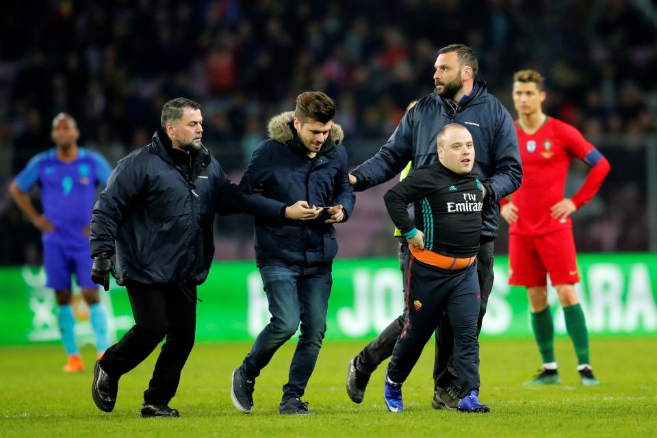  Security rush on the pitch to shepherd away Cristiano Ronaldo's fans