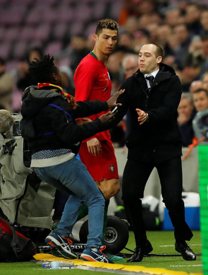  Another fan tries his luck as Cristiano Ronaldo leaves the pitch