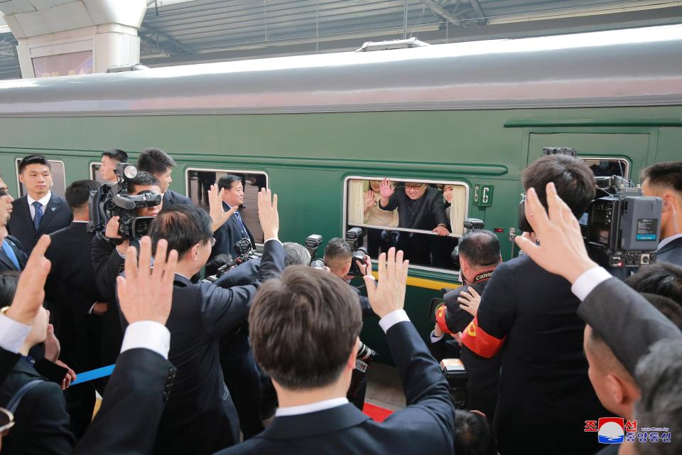  Kim is pictured waving from inside the train as it arrives in China