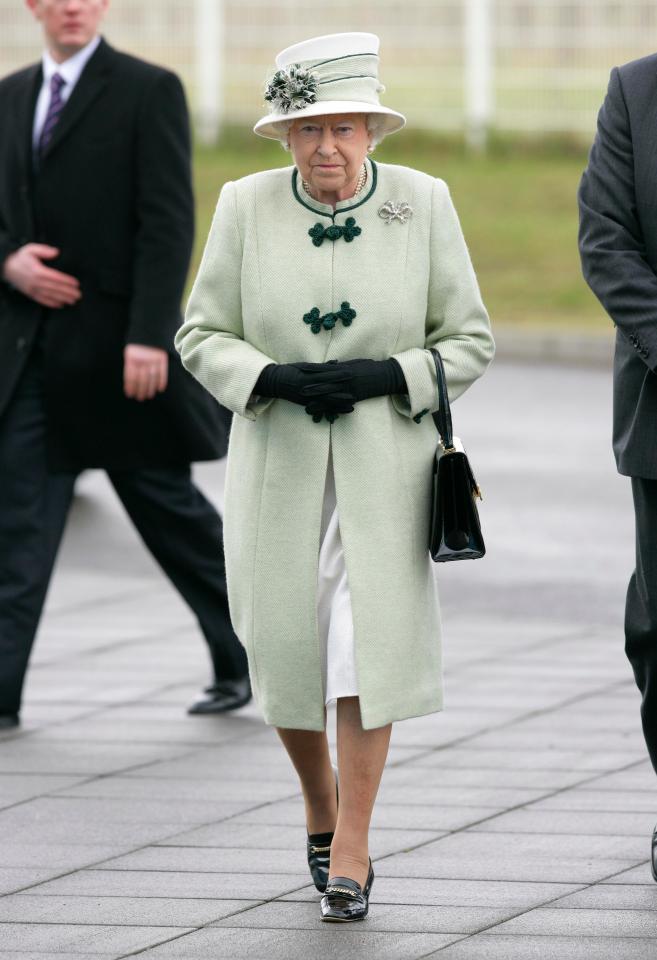  The Queen moves her handbag from one arm to the another to tell her staff she wishes to move on from a conversation