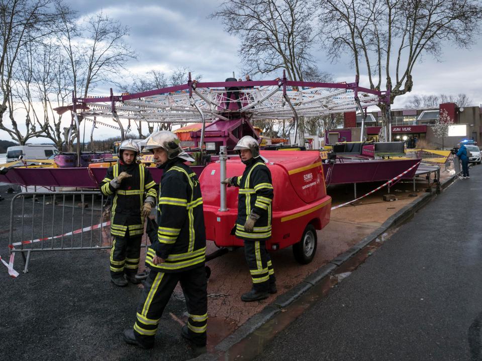  Firefighters work near the damaged fairground ride in Neuville sur Saone