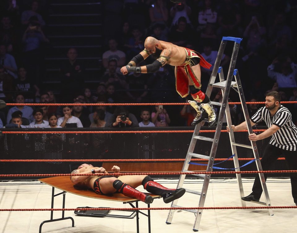  Tom La Ruffa leaps from the top of the ladder to crash through Ivan Marko