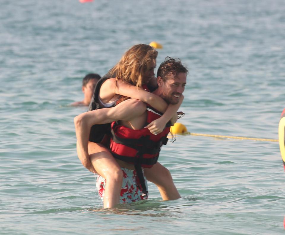  Abbey jumped on her man's back as he waded through the water