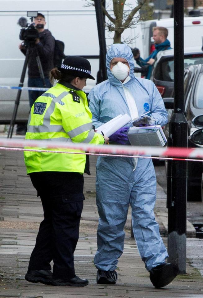  A forensic officer and police officer speak at the scene