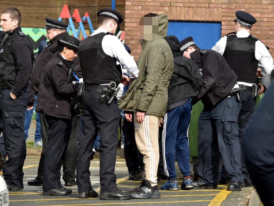  A young man's pockets are searched by police near where the mourners left floral tributes to Amaan Shakoor