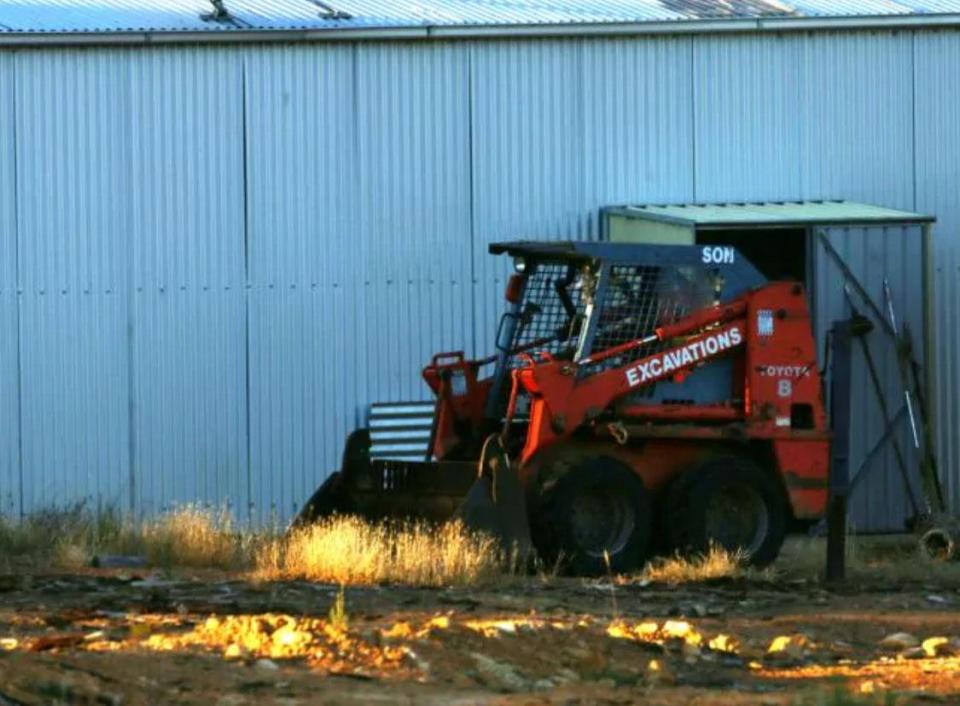 A tractor sits outside a shed on the property, which was raided in 2012