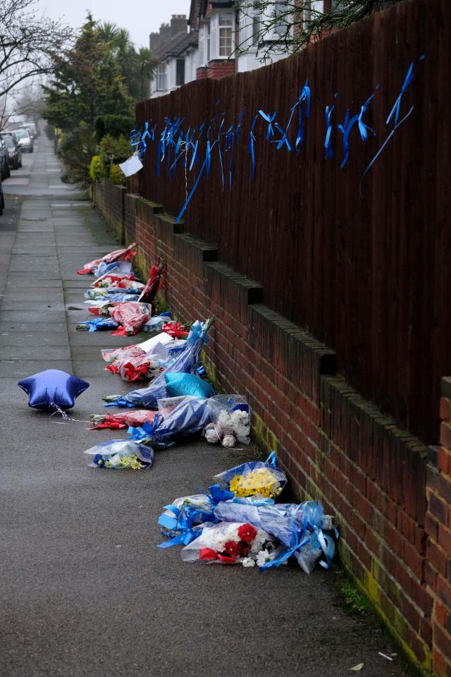  Floral tributes remain in the street today after the shrine was ripped down last night