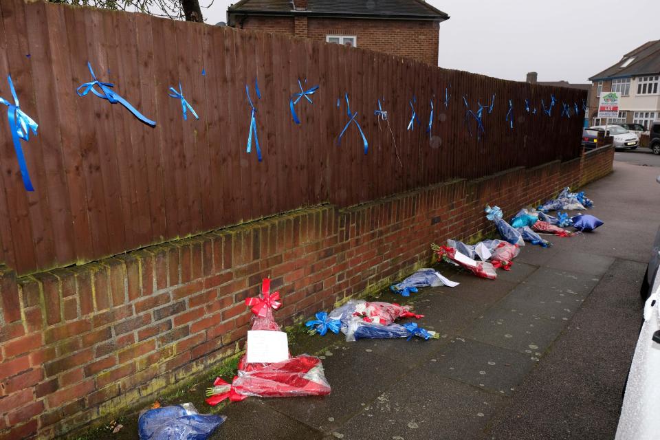  A woman with scissors was seen cutting floral tributes from lampposts, fences and street signs — and leaving them on the ground