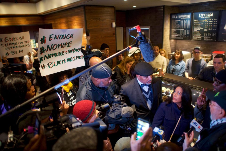  Starbucks boss Camille Hymes, centre, talks to a protester