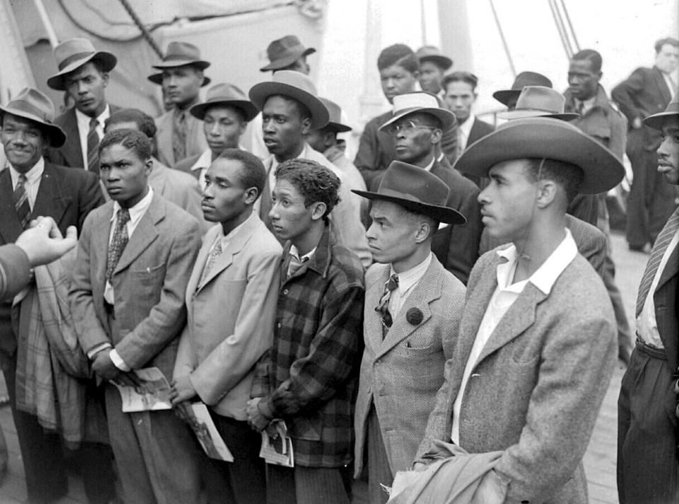 a black and white photo of a group of men in suits and hats