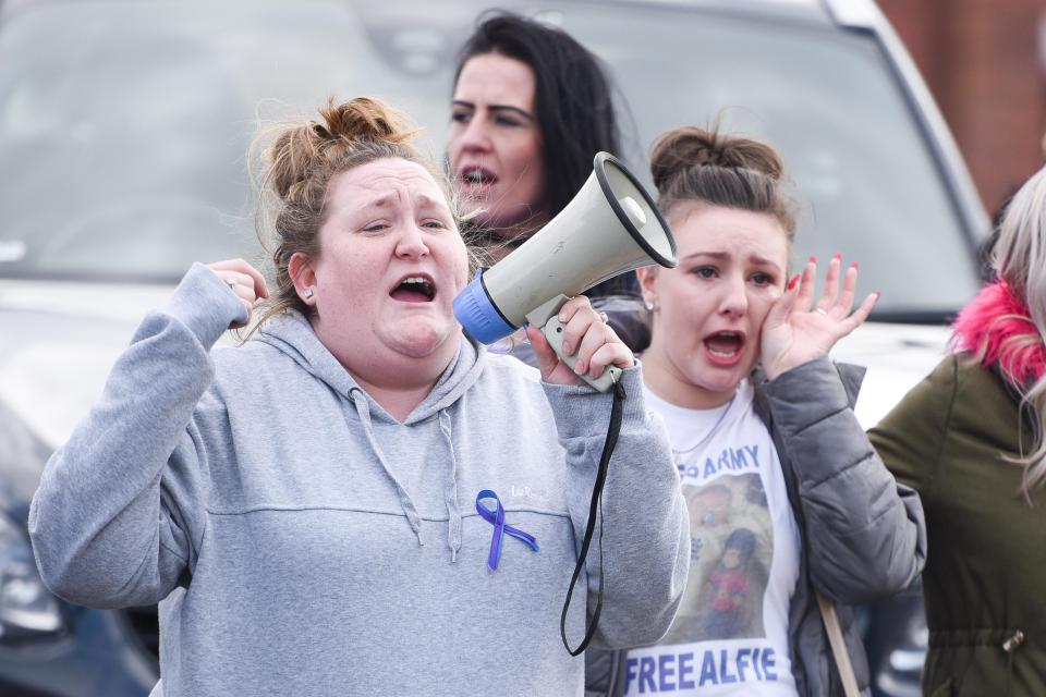 One 'Alfie's Army' supporter speaks to the crowd on a megaphone while another appears to wipe away a tear 