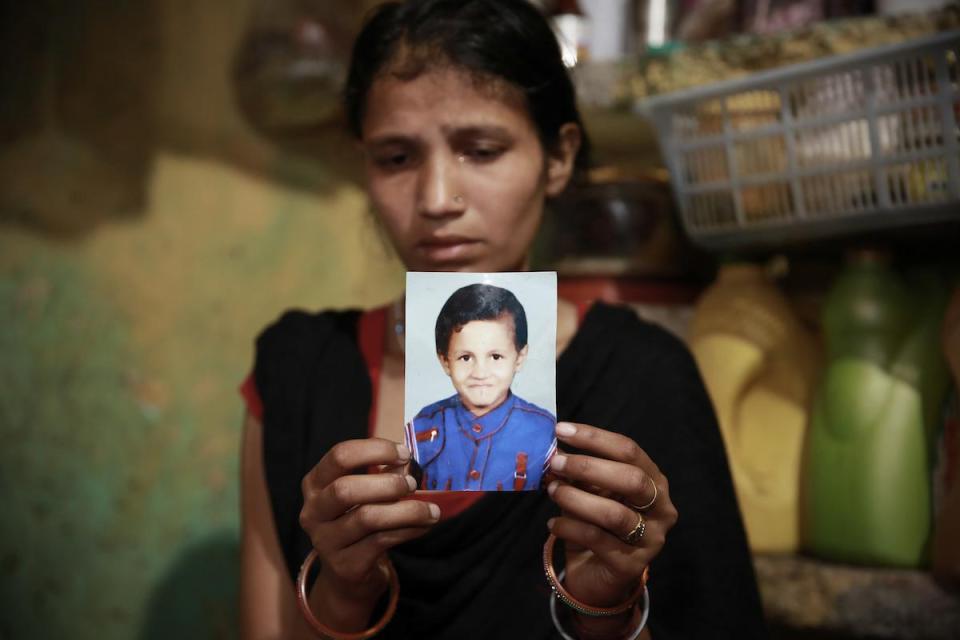  Mum Puja Devi, 25, holds a photograph of her seven-year-old son who was abducted then killed with his eyes and tongue gouged out