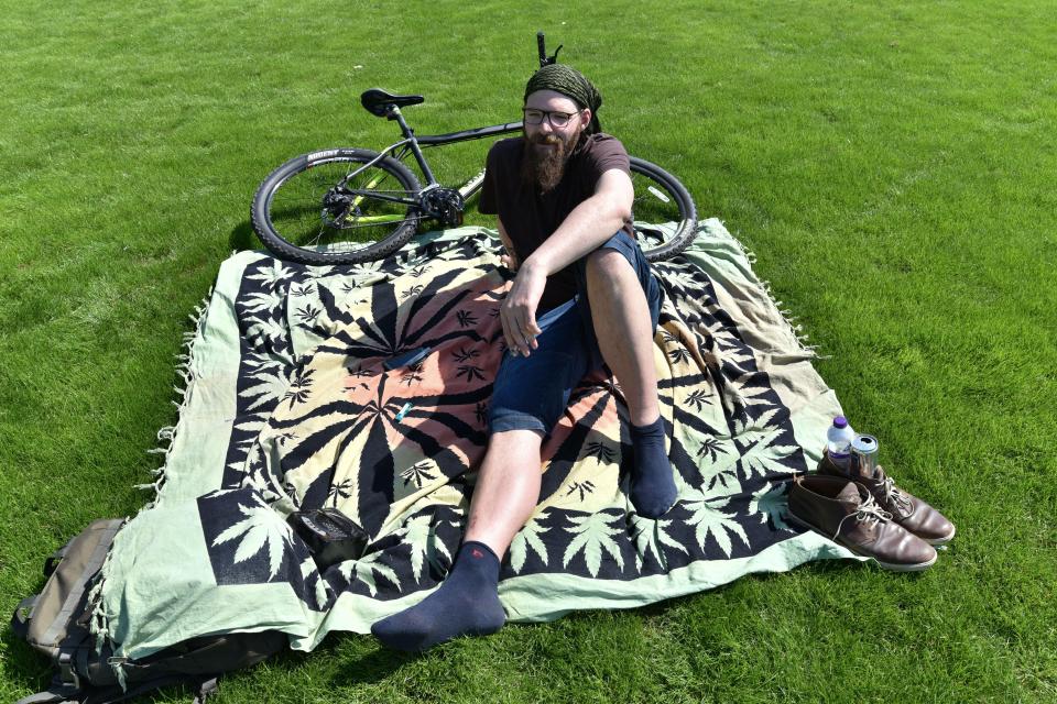  A man relaxes in the sun on 420 day in Hyde Park