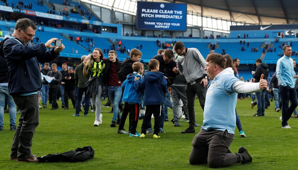  Manchester City fans hail their heroes' achievement, ignoring warnings not to stray on to the pitch