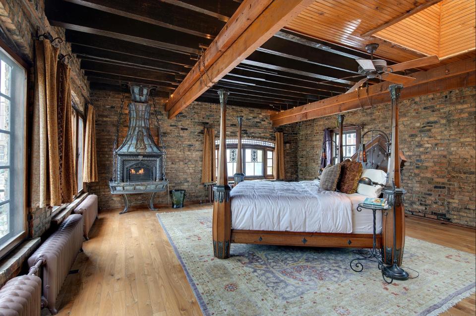  The master bedroom features exposed wood beams and its own metal fireplace