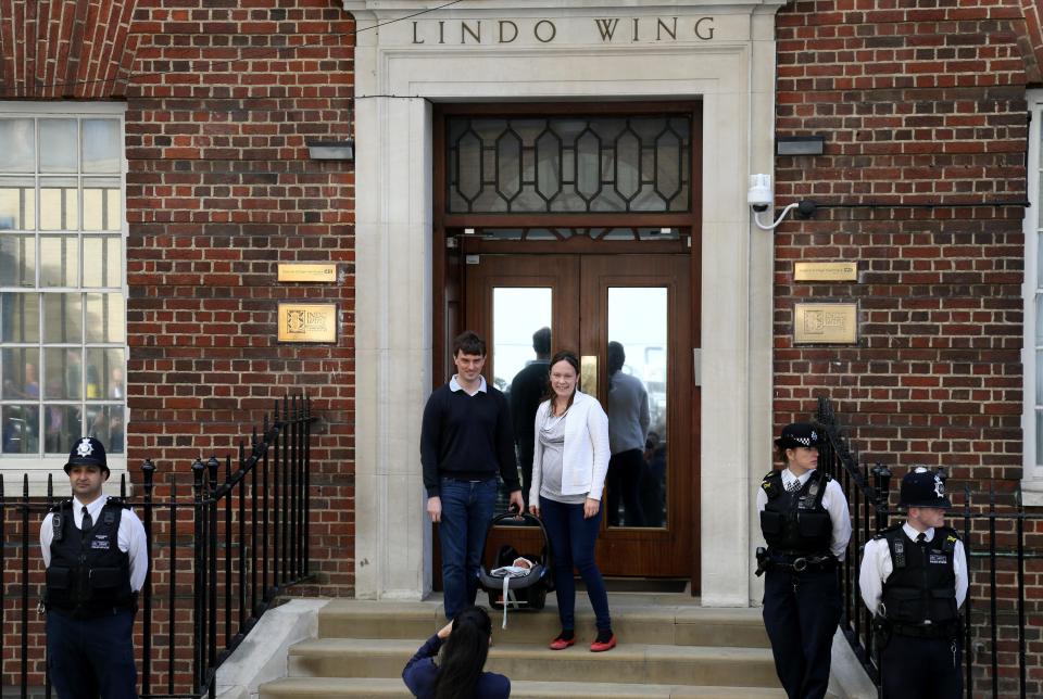  The couple safely stowed their child in a car seat while they smiled for the assembled media