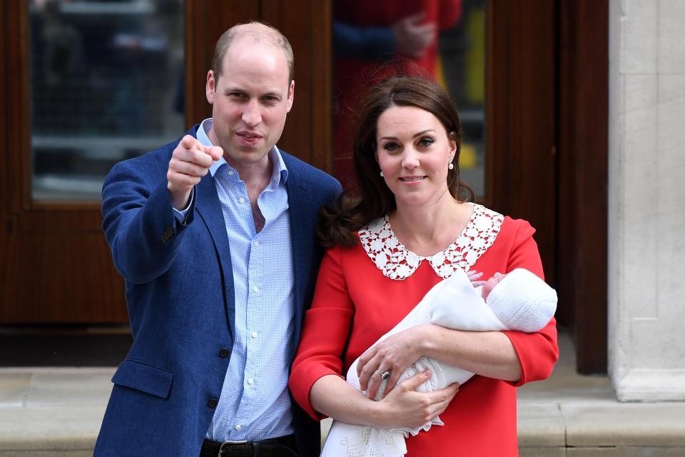  Prince William points to the cameras and the crowds as he and wife Kate's new boy is introduced to the world