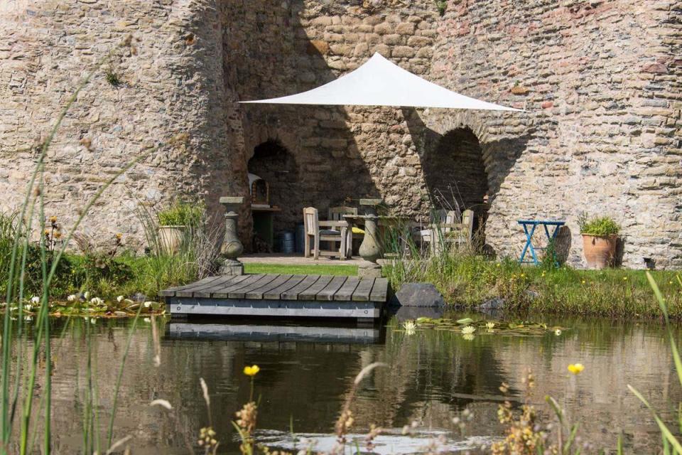  The garden contains a pond and a patio with pizza ovens in the kilns