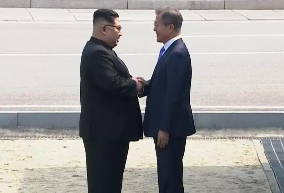  The leaders shook hands as each stood either side of the military demarcation line