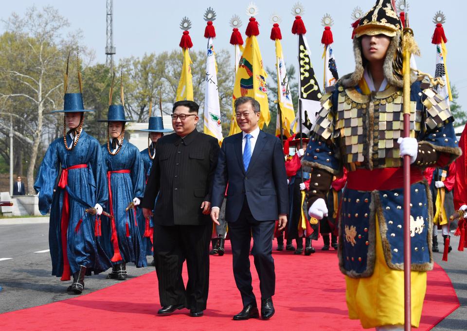  The heads of state walk together at the border village of Panmunjom where they are welcomed by an honour guard