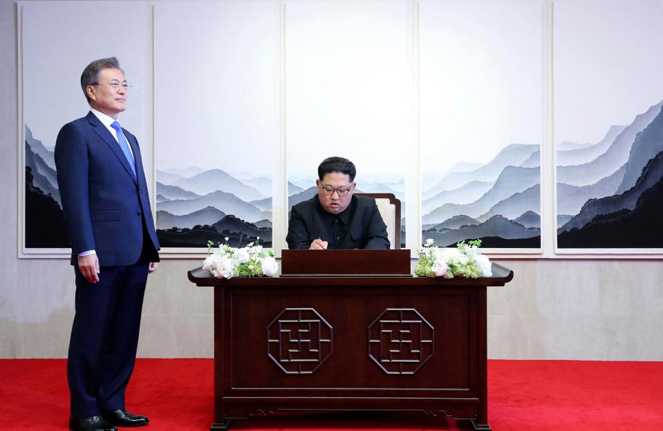  The South Korean President stands by as Kim signs a heartfelt message of peace in the book