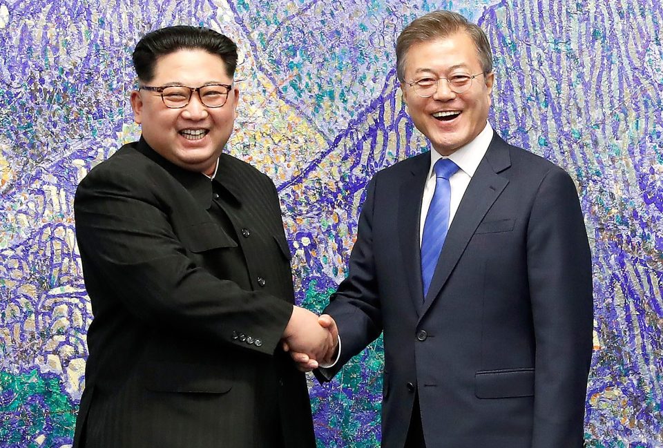  Sworn enemies Kim and Moon beamed as they shook hands for the waiting photographers at the Peace House ahead of 'unification' talks