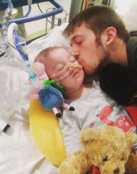  Tom Evans kisses his son as he receives treatment at Alder Hey Hospital