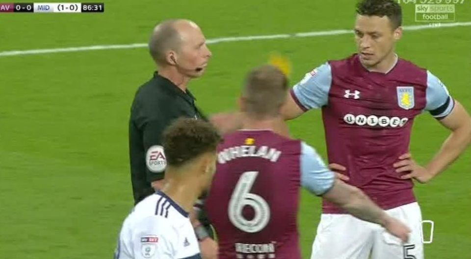  Mike Dean shows Sam Johnstone a yellow card for handling outside the penalty area