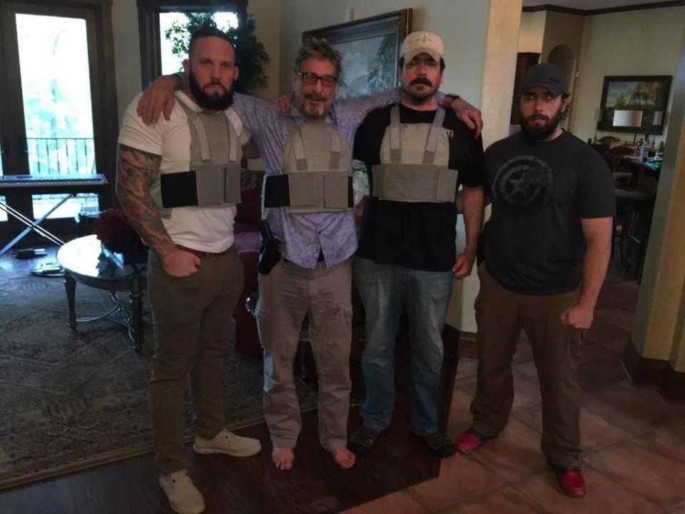  John McAfee - who says he's now on the run from the US Government - poses for a photo with his 'guards'