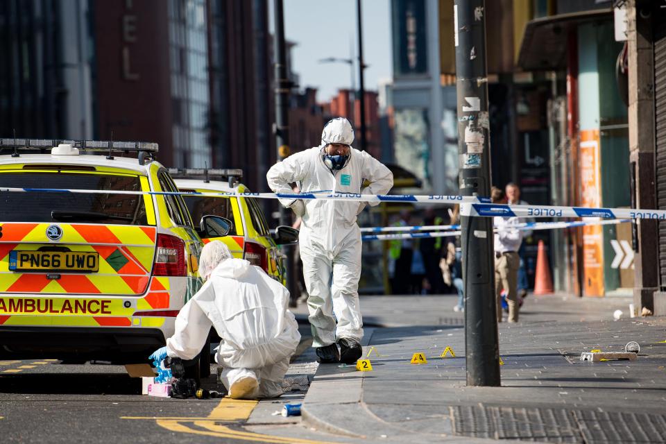  Officers in Liverpool scour the scene for clues after a man was stabbed to death in the street