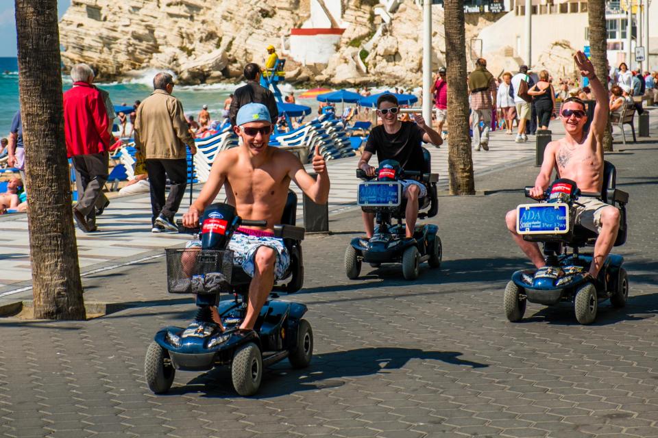  A group of lads mess about on mobility scooters on Benidorm’s main seafront