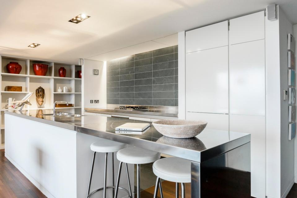  The kitchen features sleek stainless steel worktops