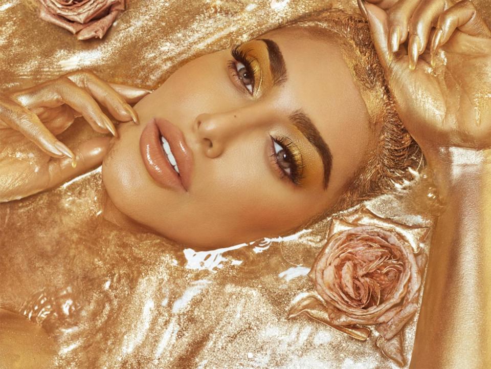  Huda poses in a gold bath surrounded by roses