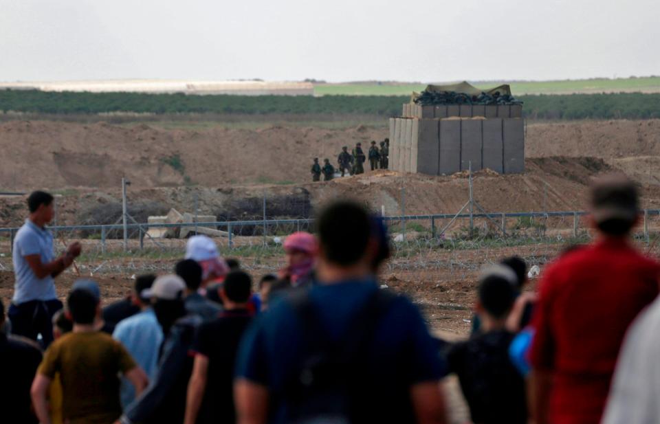  Israeli troops gather by the border fence as protesters head towards them