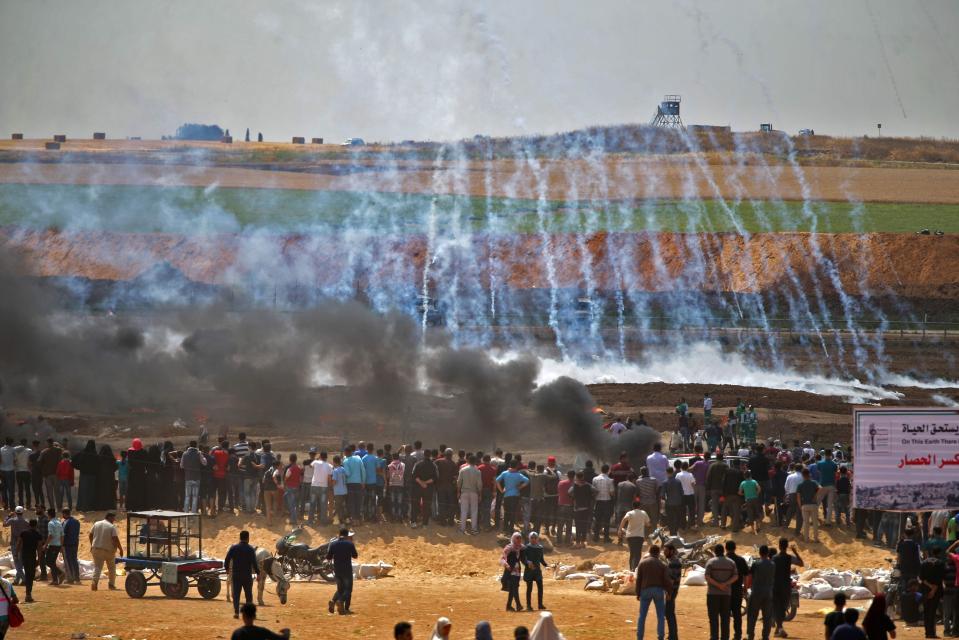  Tear gas rains down towards protesters from the Israeli side of the border