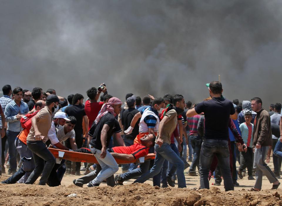  A protester is carried away on a stretcher against a backdrop of black smoke