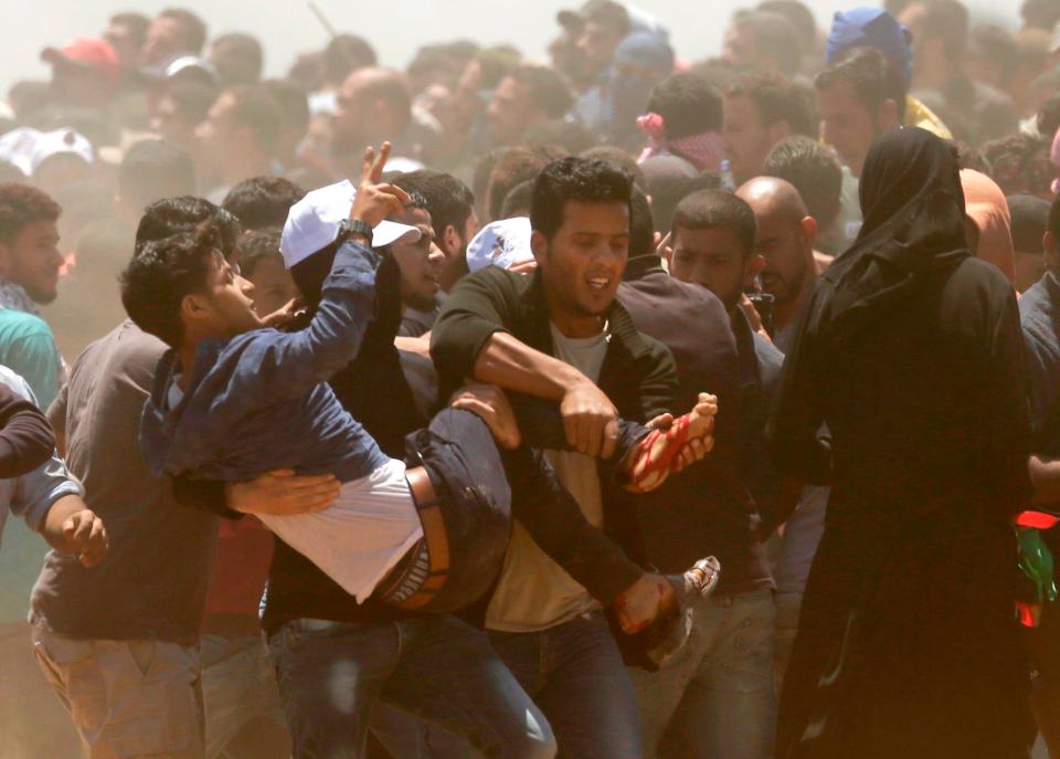  A wounded man is carried away by other demonstrators in chaotic scenes