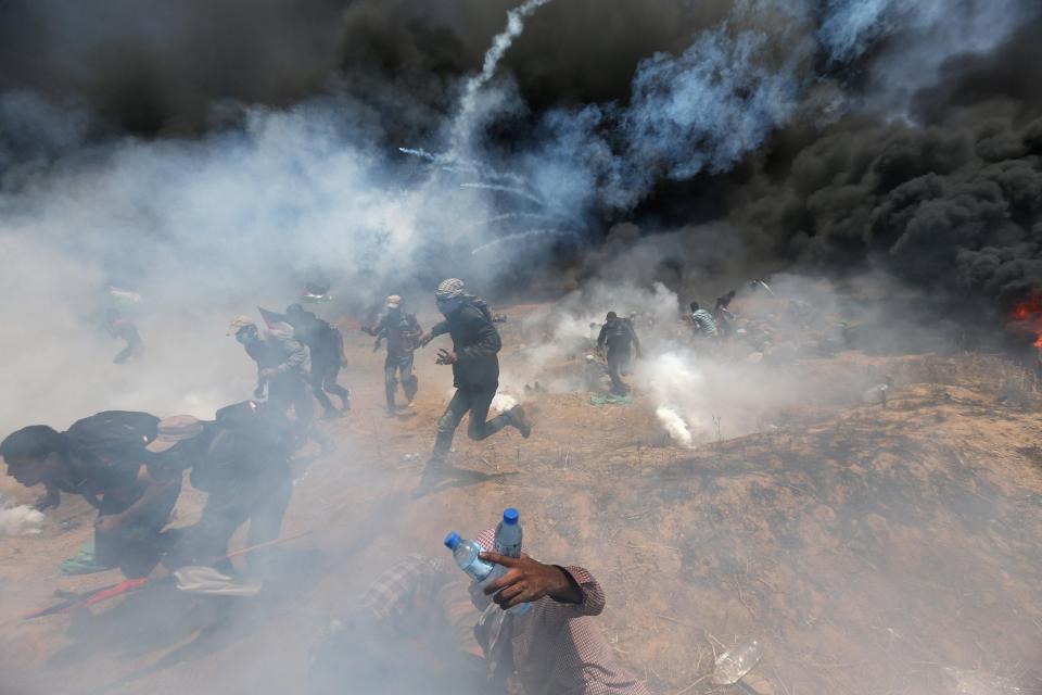  Demonstrators run through clouds of tear gas and thick black smoke